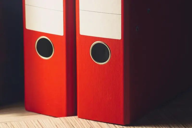Dos archivadores rojos colocados en una estantería